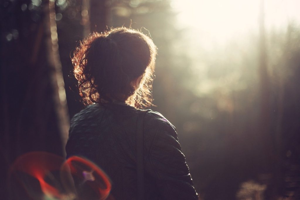 Frau in der Herbstsonne im Wald
