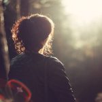 Frau in der Herbstsonne im Wald